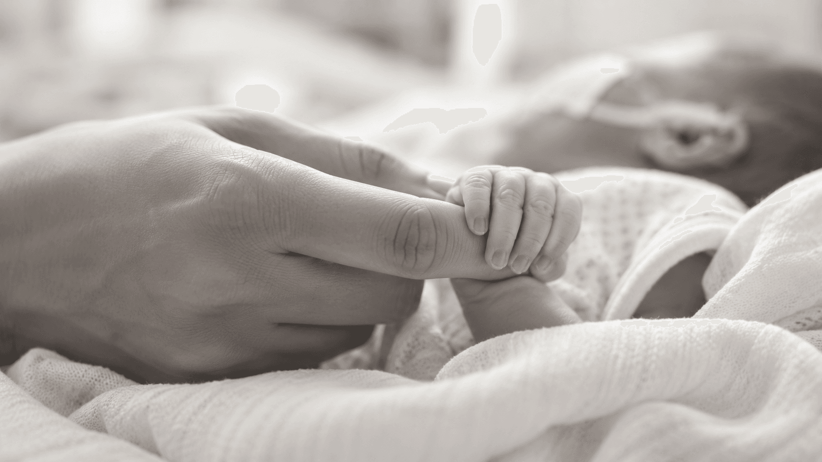 Newborn baby gently holding a parent’s hand during neonatal care at NeoLife Babies Hospital Kano